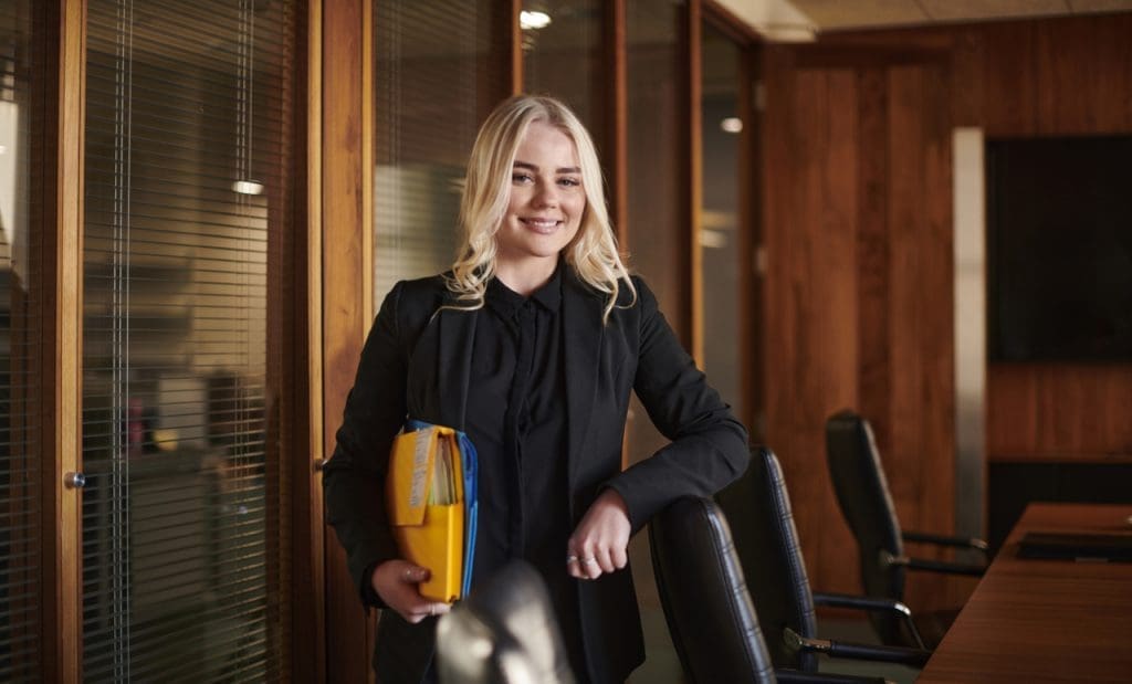 A paralegal standing in a conference room