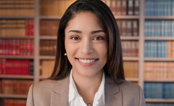 A paralegal standing in front of a bookcase of law journals